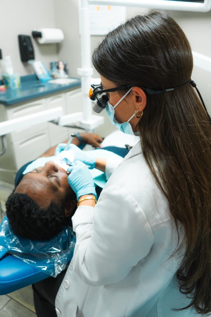 Dr. Dawood performing a dental procedure on a male patient at Glisten Dental